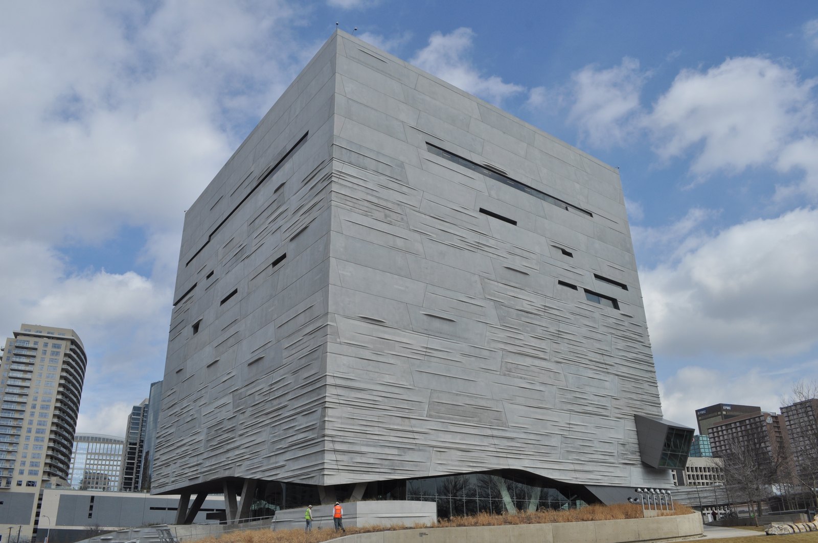 Perot 自然科學博物館的混凝土方塊，外牆有橫向錯位的層理紋路，右緣可見突出量體的玻璃電扶梯管