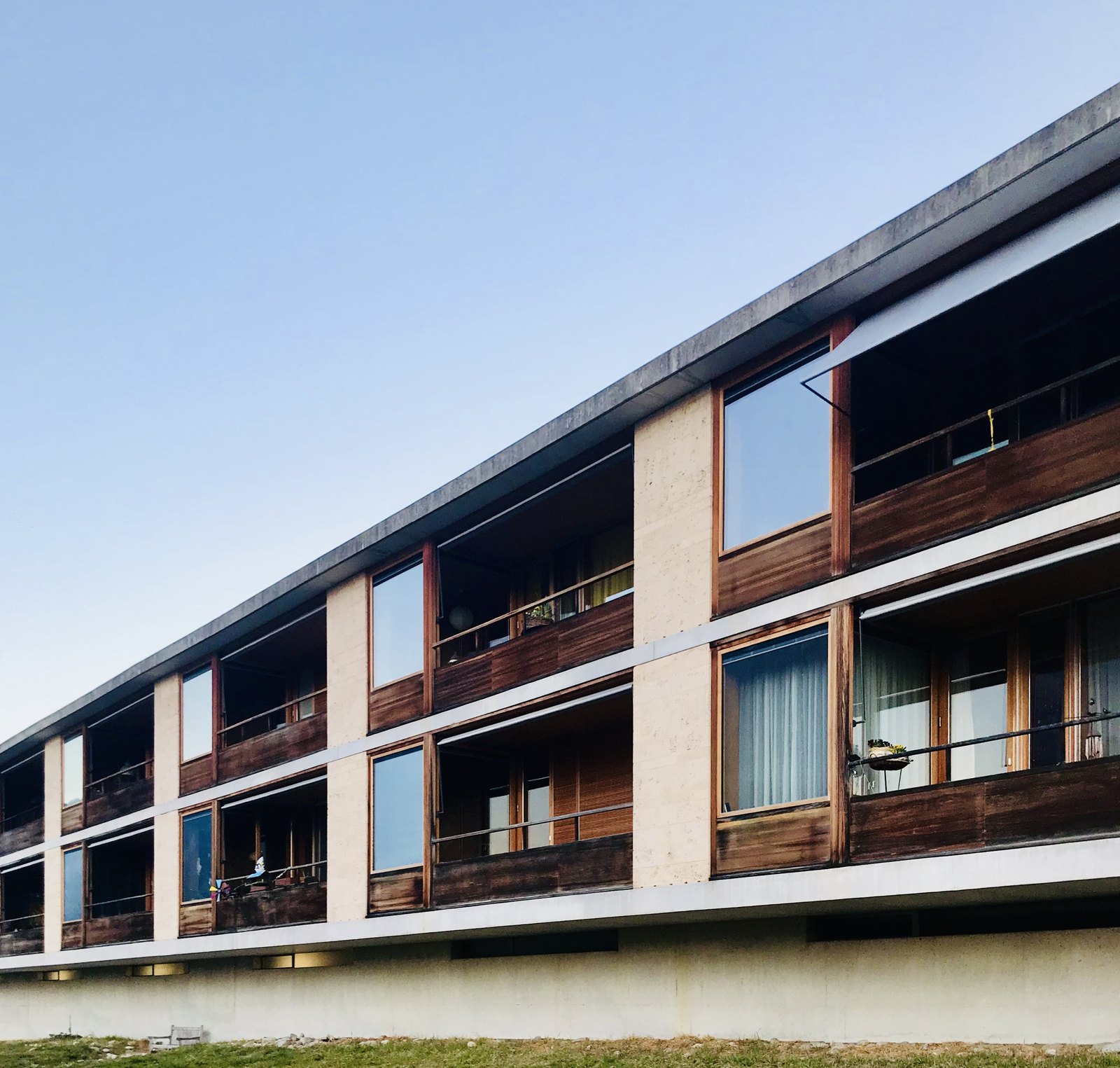 馬桑斯老人住宅的立面局部,兩層連續外廊與混凝土、凝灰岩、落葉松三種材料