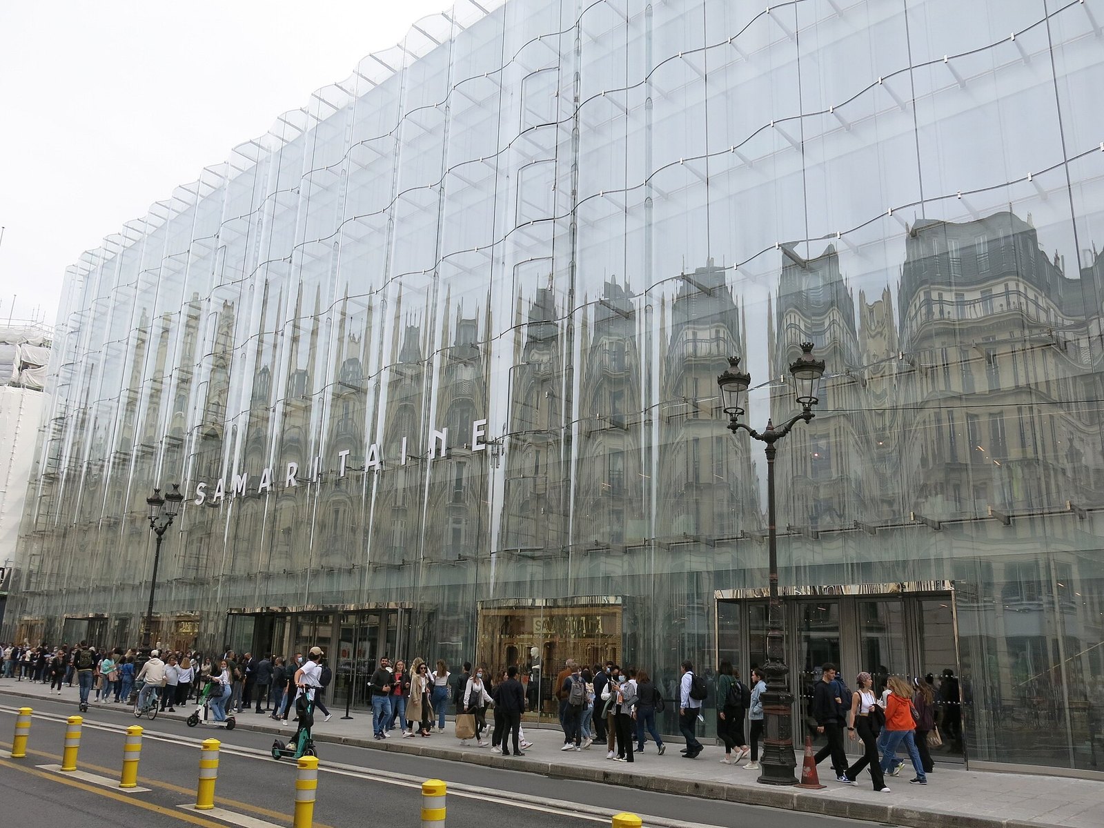 La Samaritaine 沿 rue de Rivoli 的波浪玻璃立面，映著對街的奧斯曼式街屋