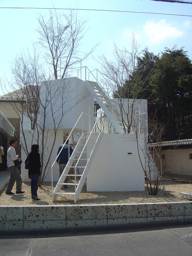 宇都宮的 House before House，白色方盒上下錯開堆疊，外側接著白色鋼梯，盒子上種著樹