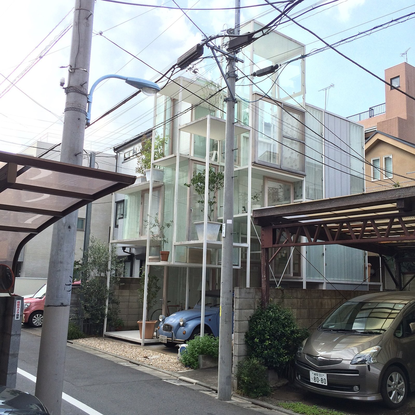 東京住宅區巷弄裡的 House NA,白色細鋼架與玻璃構成,看得見高低錯開的樓板